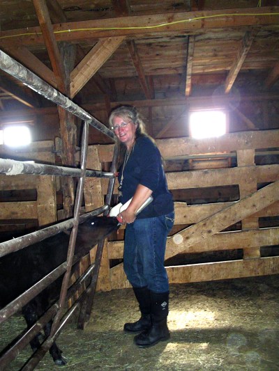 Gail Lee of Saratoga, Wyoming feeds a bottle calf on the ranch in her Chore boots from The Original Muck Boot Company.