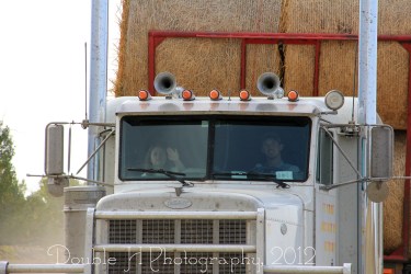 RealRancher Holly Hamilton helps wind straps from a semi-truck load of hay on her family ranch near Lance Creek, Wyo.